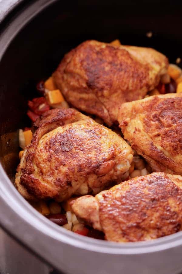 Photo of chicken thighs in slow-cooker after being browned.
