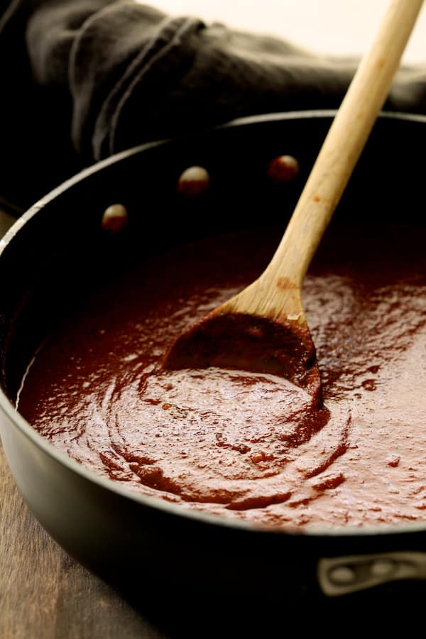 Photo of sauce being made and stirred with wooden spoon in a skillet.