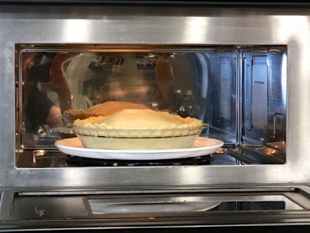 Photo of uncooked pie in a microwave.