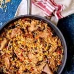 Chicken, Orzo and Black Bean Skillet in the skillet being stirred with wooden spoon.