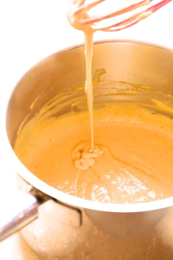 Photo of cheese sauce in saucepan.