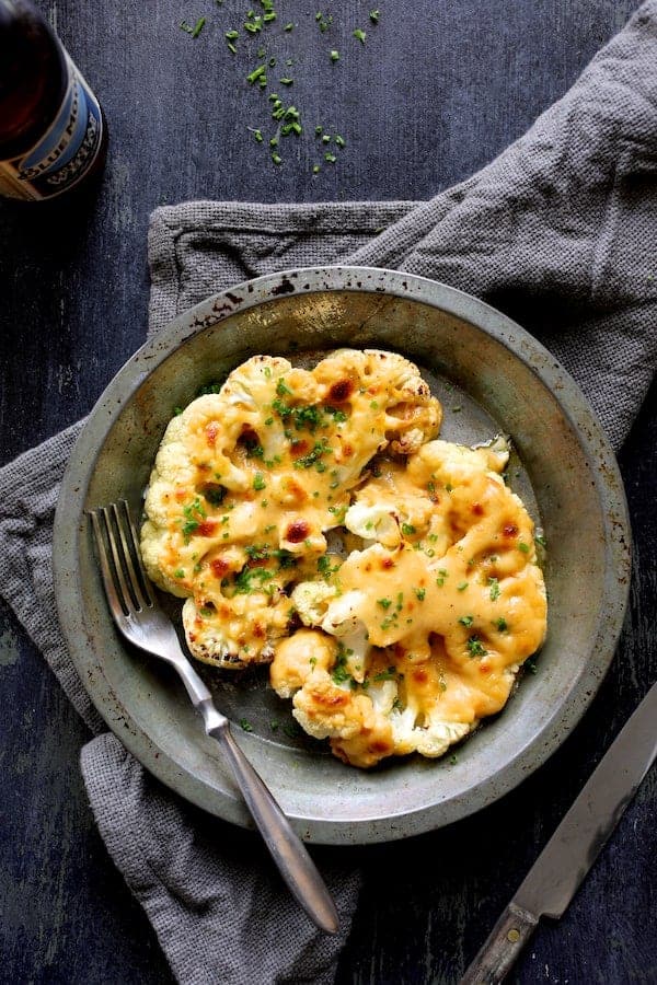 Photo of Cauliflower Welsh Rarebit in metal serving dish on gray napkin.