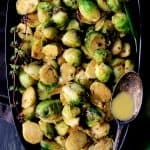 Roasted Brussels Sprouts with Thai Green Curry Butter on black platter.