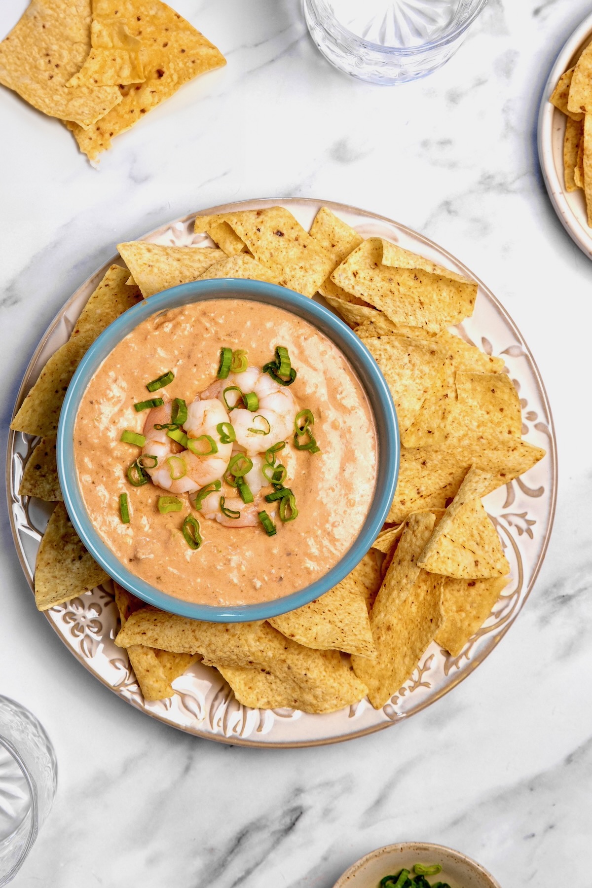 Creamy Shrimp Salsa Dip in bright blue bowl on platter with tortilla chips.