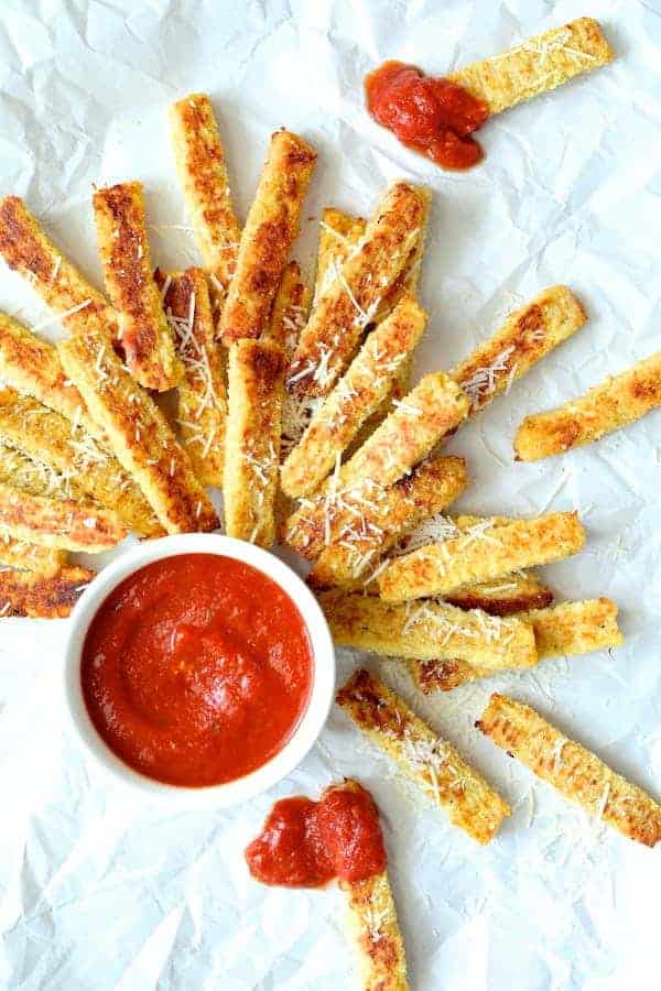 Photo of Spaghetti Squash Fries on white paper with marinara sauce.