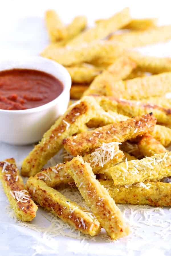 Photo of a pile of Spaghetti Squash Fries next to bowl of marinara sauce.