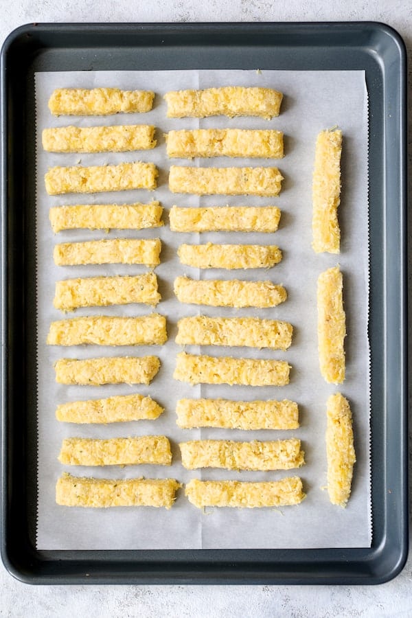 Photo of formed Spaghetti Squash fries on parchment paper on baking sheet ready for baking.