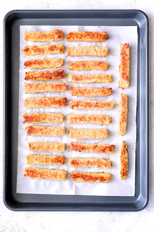 Photo of baked Spaghetti Squash Fries on parchment paper on baking sheet.