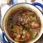 Chicken Pinot Noir in blue Dutch oven on blue striped towel.