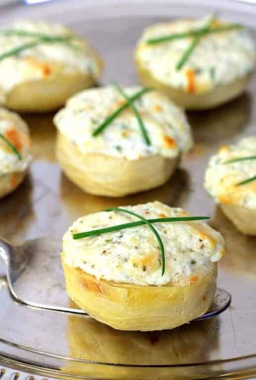 Goat Cheese Stuffed Artichoke Bottoms on silver platter garnished with chives.