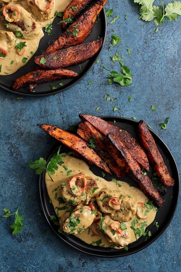 Photo of Spicy Tahini Pork Medallions with Harissa Roasted Sweet Potato Wedges on blue background.