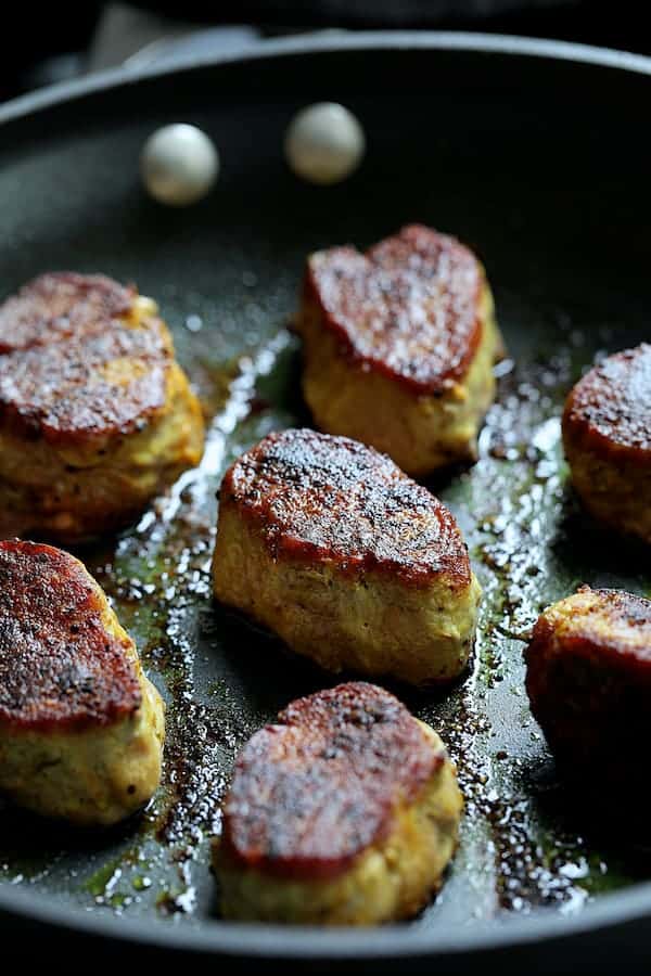 Photo of pork medallions in skillet after being seared.
