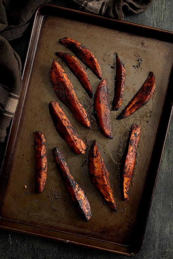Photo of Harissa Roasted Sweet Potato Wedges on baking sheet.