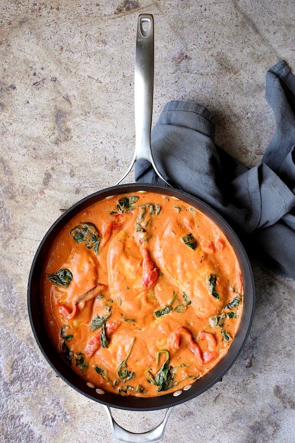 Photo of Chicken in Rosa Sauce with Roasted Red Bell Pepper and Spinach in skillet.