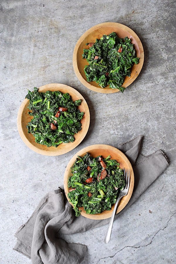 Spicy Sautéed Kale with Andouille Sausage - Overhead shot of dish on three wooden plates