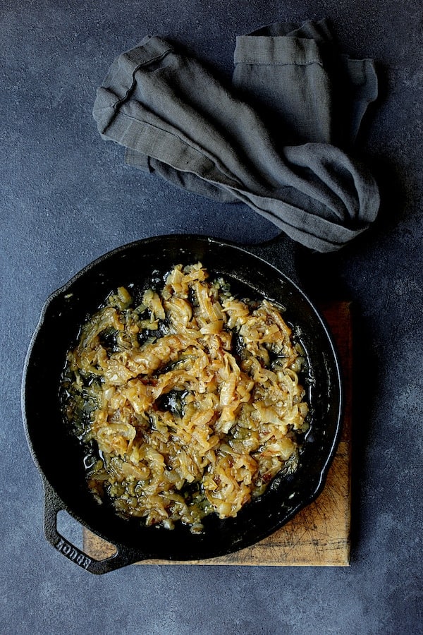 Photo of cooked onions in cast iron skillet.