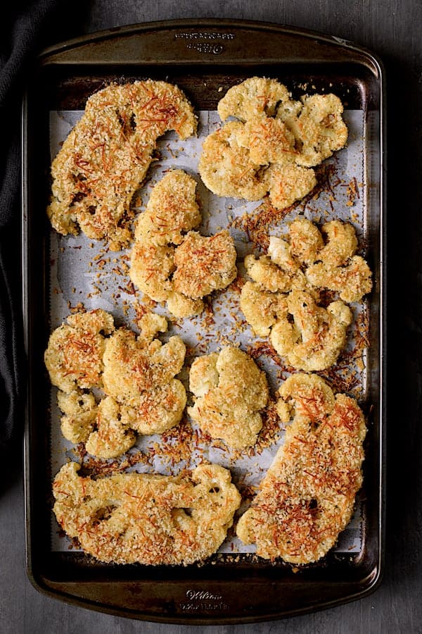 Photo of cauliflower steaks on baking sheet after being baked.