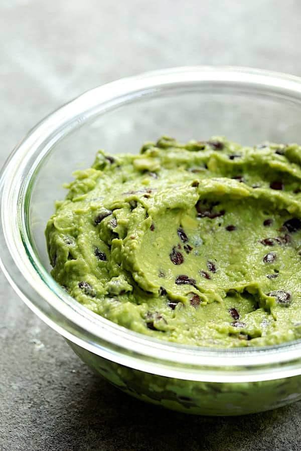 Photo of black bean guacamole in glass bowl.