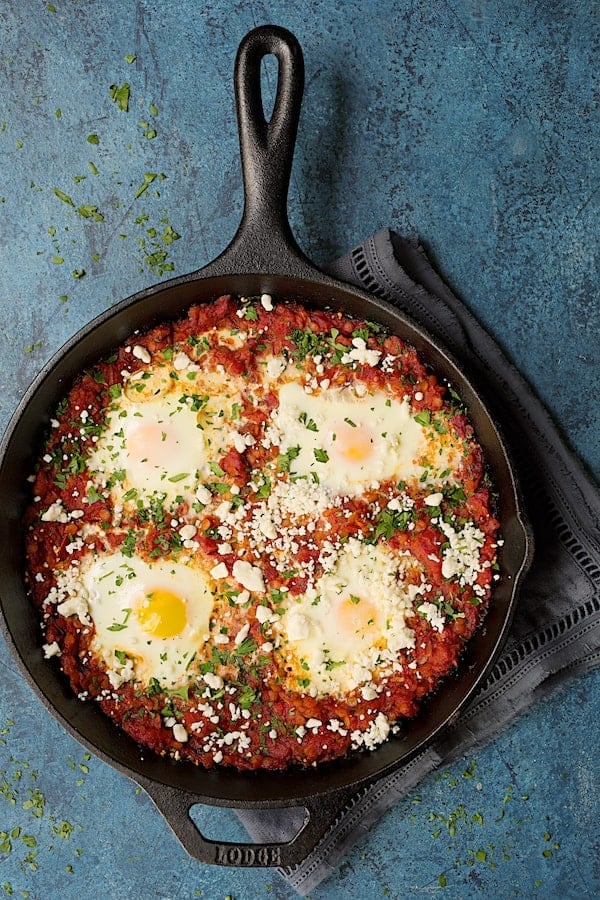 Photo of Shakshuka with Red Lentils and Feta Cheese in cast iron skillet.