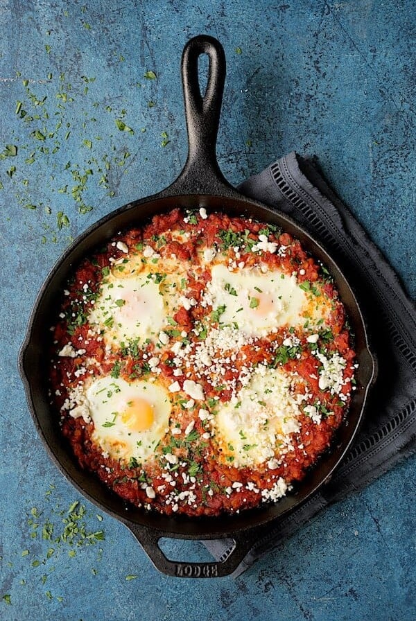 Shakshuka with Red Lentils and Feta Cheese in a cast iron skillet.