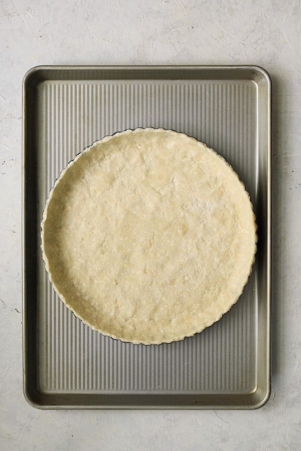 Photo of unbaked tart crust on baking sheet.