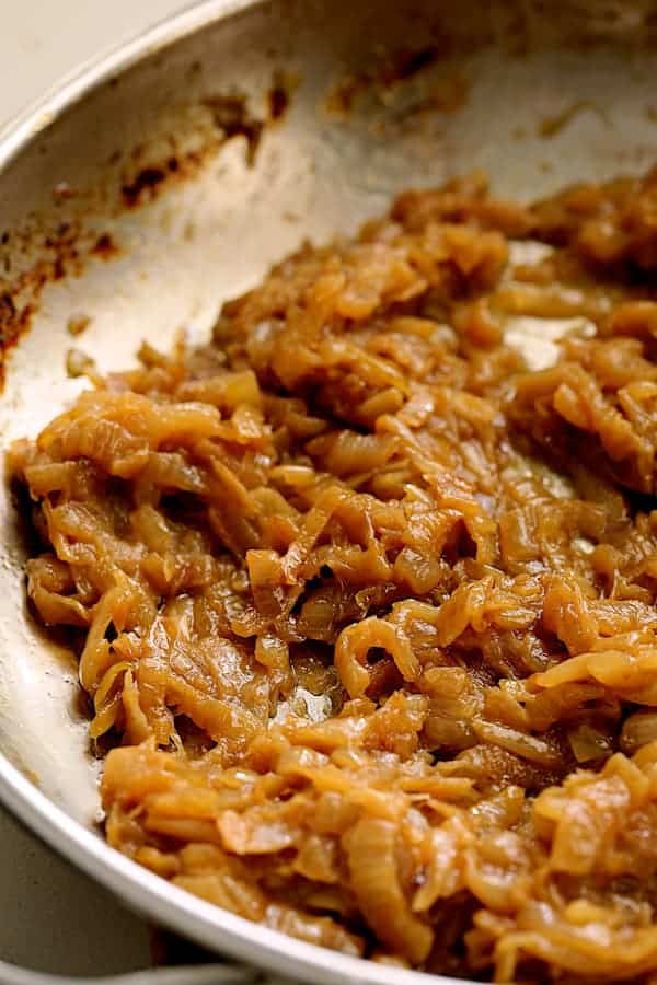 Photo of caramelized onions in stainless steel skillet.