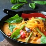 Vegetable Thai Red Curry in a black bowl with red spoon.