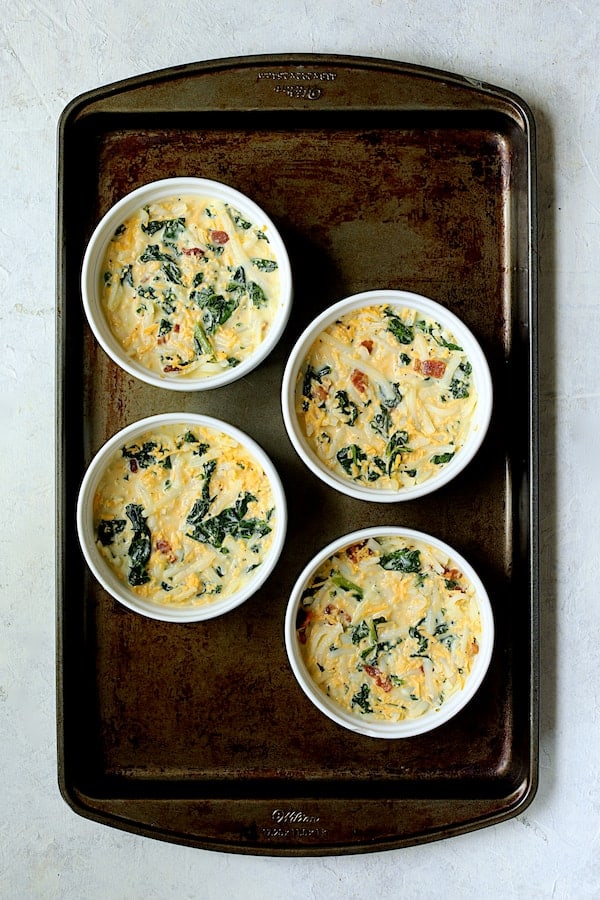 Photo of frittatas with custard added on baking sheet before being baked.