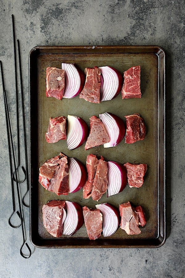 Overhead shot of meat and onions before threading skewer through