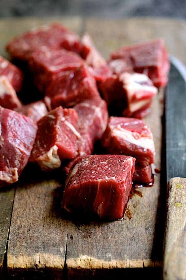 Cubed beef on wood cutting board