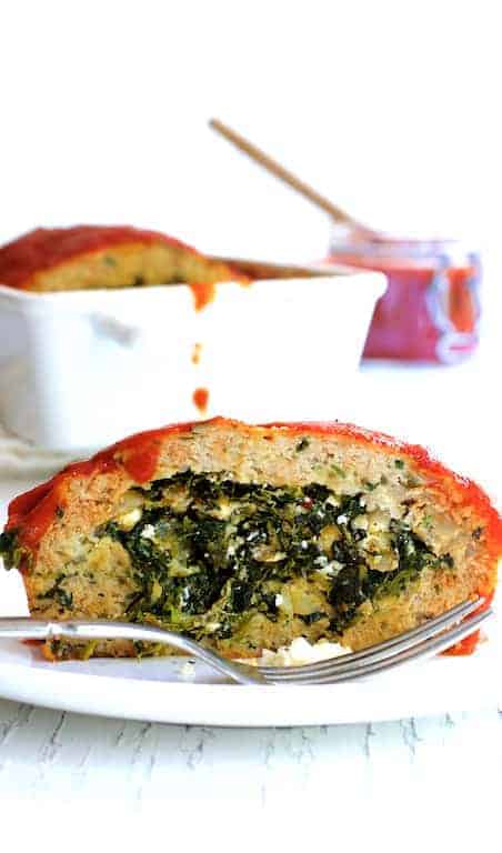 Slice of Spinach and Feta-Stuffed Turkey Meatloaf on white plate.