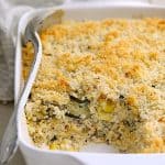 Zucchini, Yellow Squash and Quinoa Casserole in white baking dish with a serving removed.