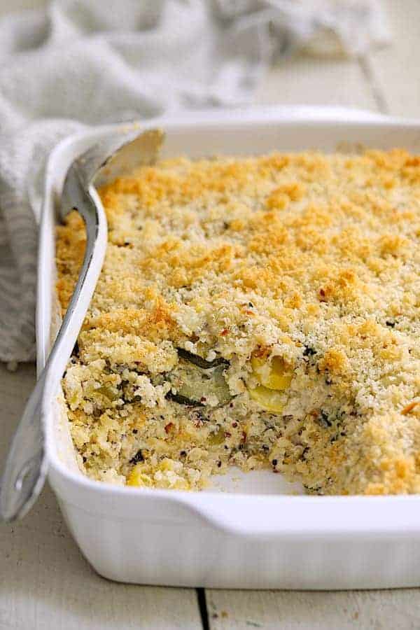 Photo of Zucchini, Yellow Squash and Quinoa Casserole in white baking dish with some removed to show inside of casserole.