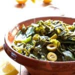 Braised Greens with Olives and Lemon in stoneware bowl.