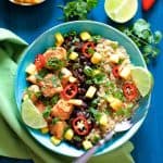 Cuban Chicken and Black Bean Quinoa Bowls garnished with lime wedges and cilantro.