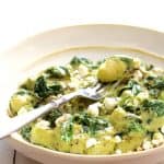 Gnocchi with Spinach and Avocado Goat Cheese Sauce in white bowl.