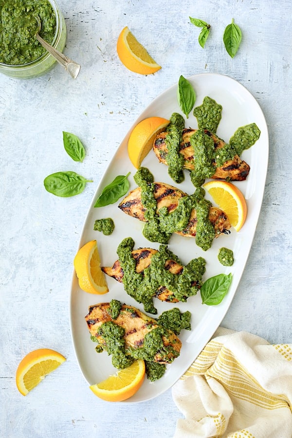 Photo of Grilled Citrus Chicken with Spicy Basil Chimichurri Sauce on white oval platter.
