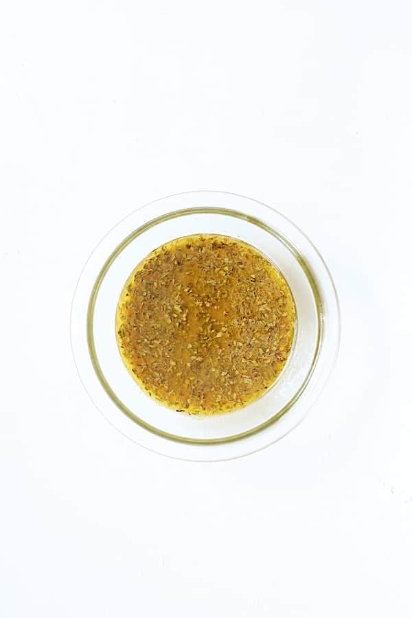 Photo of citrus marinade in glass bowl on white background.