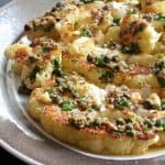 Roasted Cauliflower Steaks with Mustard Caper Brown Butter on gray-rimmed platter.