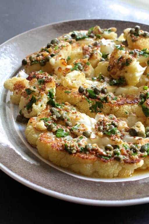 Roasted Cauliflower Steaks with Mustard Caper Brown Butter on gray-rimmed platter.
