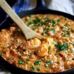 Smothered Shrimp with Andouille Sausage in cast iron skillet.