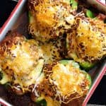 Four Southwestern Beef and Barley Stuffed Bell Peppers in white baking dish.