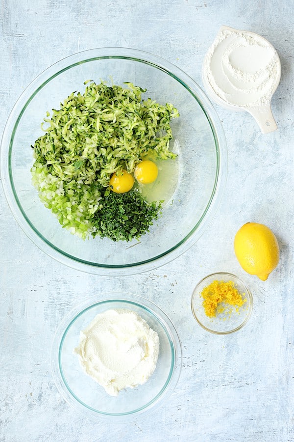 Photo of ingredients for Zucchini Ricotta Fritters ingredients in glass bowls.