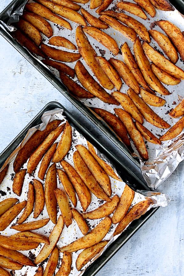 Photo of roasted potato wedges on two sheetpans.