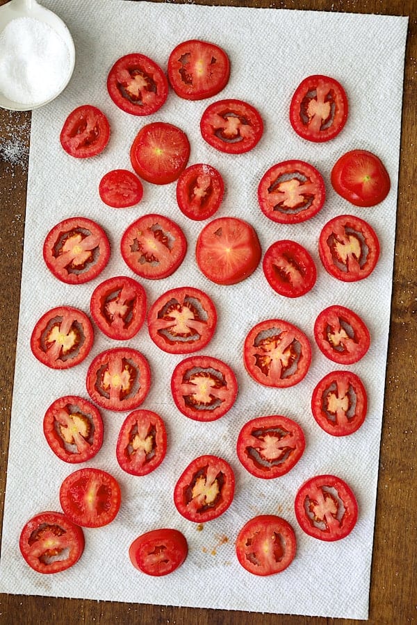 Photo of tomatoes draining on paper towels after being salted.
