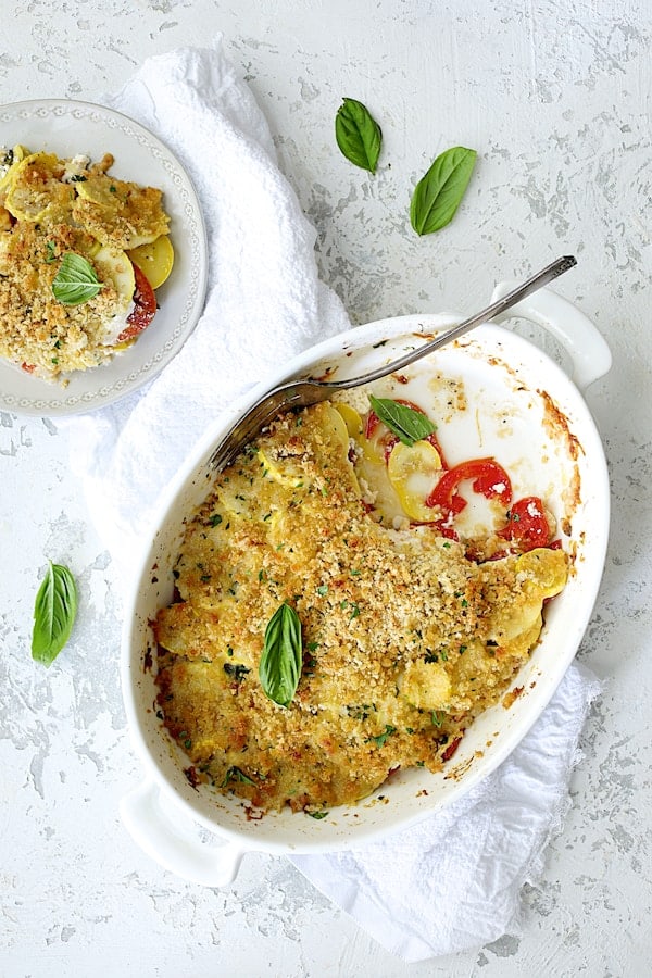 Photo of Yellow Squash and Tomato Gratin with Two Cheeses with some of the gratin served onto a small white plate.