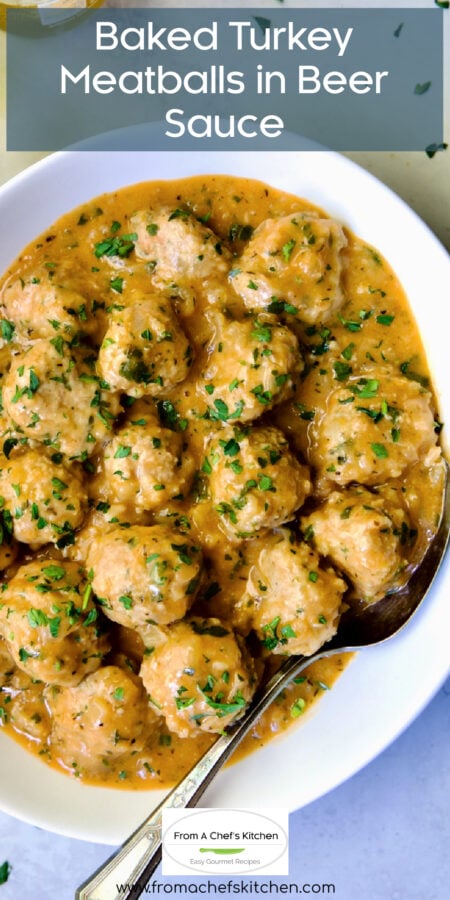 Pinterest graphic for Baked Turkey Meatballs in Beer Sauce showing them in white oval bowl with serving spoon garnished with fresh parsley.