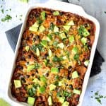 Black Bean and Yellow Squash Enchilada Casserole with serving spoon before being cut.