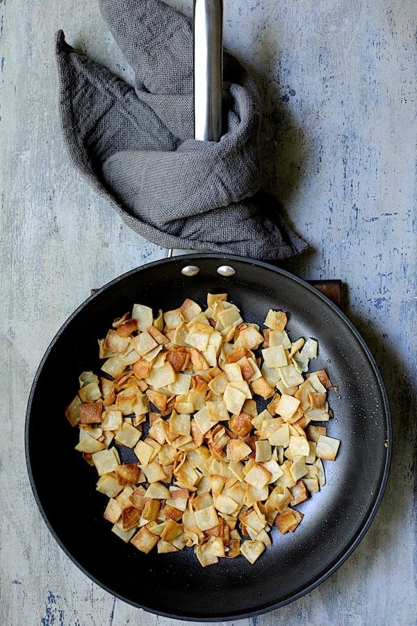 Photo of fried tortilla squares in skillet.