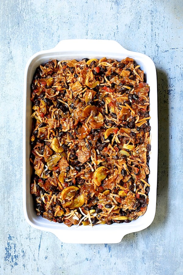 Photo of assembled casserole in white ceramic baking dish.